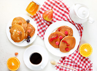 Healthy summer breakfast,homemade classic american pancakes with fresh berry and honey, morning light white stone background copy space top view