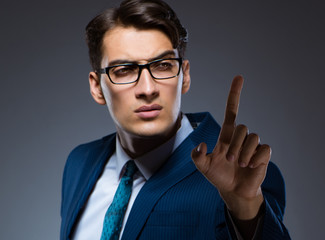 Businessman pressing virtual buttons on gray background