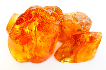 Transparent colored pieces of amber on a white background. Ancient petrified resin. Composition of...