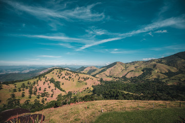 Fototapeta premium Green Hills and Mountains with Trees Under Blue Sky on Sunny Day