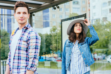 Guy at bus stop looking at girl next to him, waiting for tram, love at first sight feelings concept.