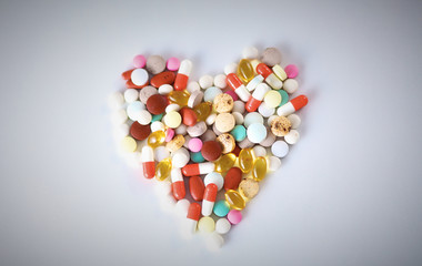 Close up of pills spread over the table with stethoscope and he