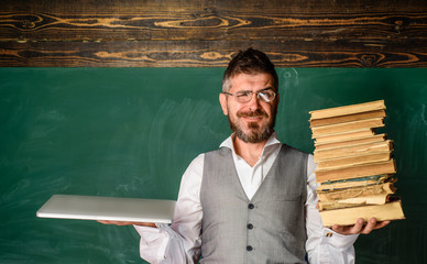 Teacher with books and laptop in front of board. Electronic library, e-book. Online education,...