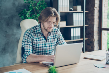 Portrait of concentrated guy typing looking modern technology wearing checkered plaid shirt eyewear...