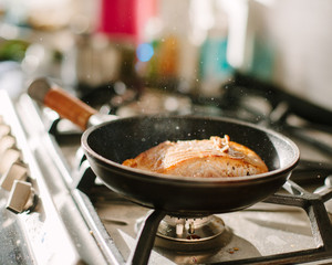 Salmon sizzling on a frying pan