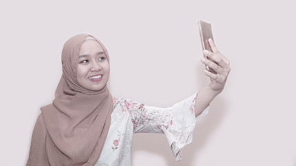 Portait of asian muslim woman wearing head scarf or hijab using smartphone