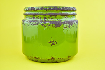 Green jar. Rusty tin view, ceramic jar. Clean for your message, advertising or company logo. yellow background