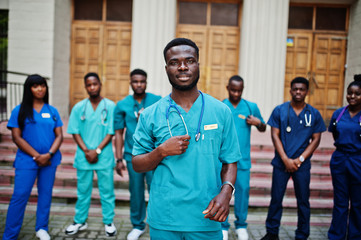 Group of african medical students posed outdoor against university door.