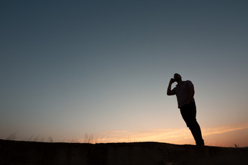 Fototapeta na wymiar silhouette of man with cell phone at sunset