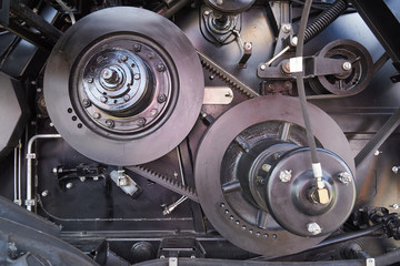 Belt drive with automatic belt tensioning mechanism. Fragment of a combine harvester