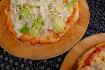 Close-up, two pieces of hot pizza with cheese  in a cafe on a wooden background.