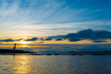 Wide shot of beautiful sunrise colors on the shore of Lake Llanquihue with iconic volcanoes in the background