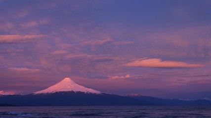 beautiful sunset colors in the sky and over the glacier and snow of the Osorno volcano