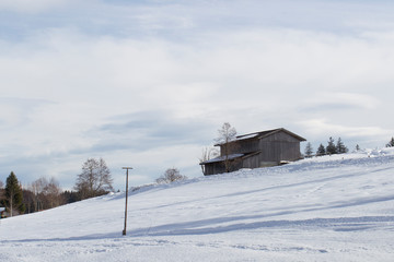 A snowy hut in winter in the Ammergau Alps near the spa town Bad Bayersoyen in Bavaria