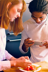 Black man and Caucasian redhead woman recording the plate