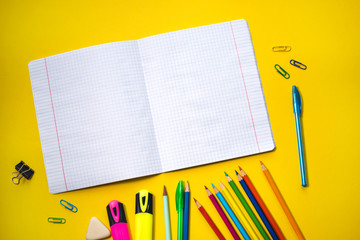 School supplies on yellow background. Top view. Copy space.