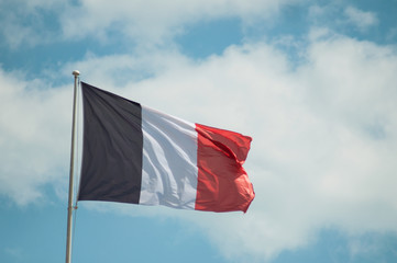 closeup of french flag floating on Cloudy sky background