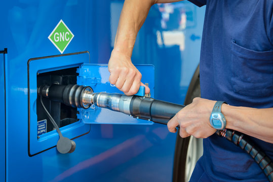 A man recharges a vehicle with compressed natural gas fuel, ecological fuel known as CNG