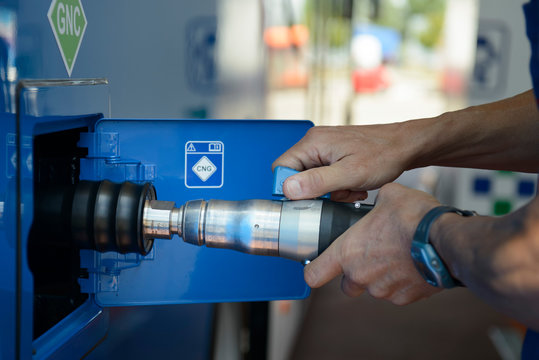 A man recharges a vehicle with compressed natural gas fuel, ecological fuel known as CNG