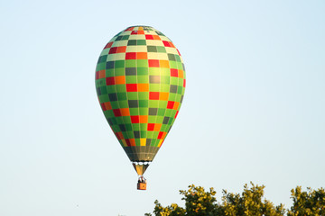 Beautiful view of clear sky with colorful baloon flying over a small countryside city.