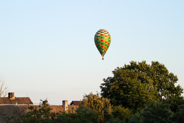 Beautiful view of clear sky with colorful baloon flying over a small countryside city.