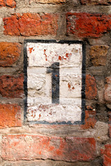 hausnummer 1 an einer roten backsteinwand