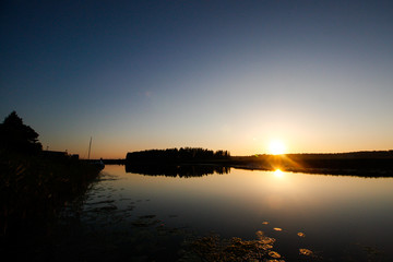 Cloudy evening view of river Lielupe flowing though small village.