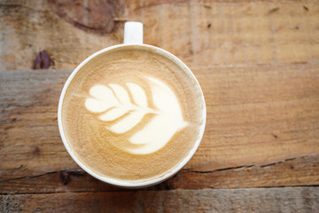 Coffee cup latte art on the wooden table. 