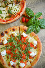 Raw pizza. Rolled out dough on a cutting Board with tomato paste, mozzarella and spinach. On rustic background