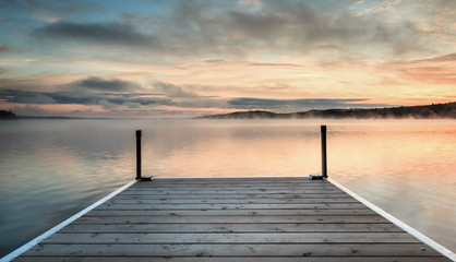 Dock on a lake at sunrise