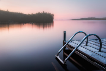 sunset on lake with a dock and ladder