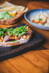 Burger with mushrooms, fried onions and cheese on rustic background