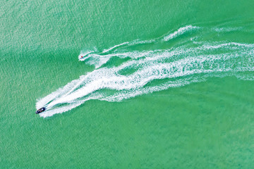 Wake boarder towed by jetski in blue waters