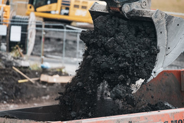 A digger and dump truck move dirt to make room for the foundations of the new Waverley School in...
