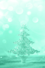 Silver glitter Christmas tree on neon blue background with lights bokeh, copy space. Greeting card for new year party. Festive holiday concept. Banner