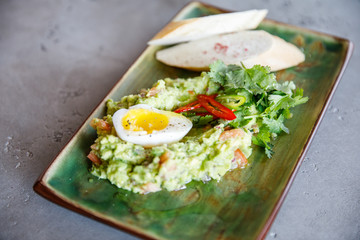 salad of eggs, spinach, cheese, pate lies on a plate in a restaurant