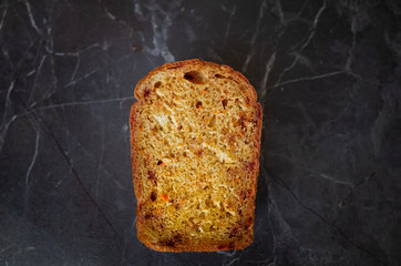 Vegetarian bread with beets and carrots lies on a dark gray countertop. The concept of a healthy diet, baking homemade bread. Minimalism, place for text.