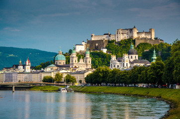 Naklejka na ściany i meble Panoramic view of the historic city of Salzburg with Fortress Hohensalzburg in the background as seen from river Salzach in Salzburg, Austria