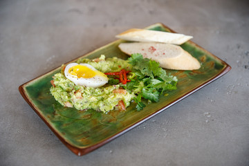 salad of eggs, spinach, cheese, pate lies on a plate in a restaurant