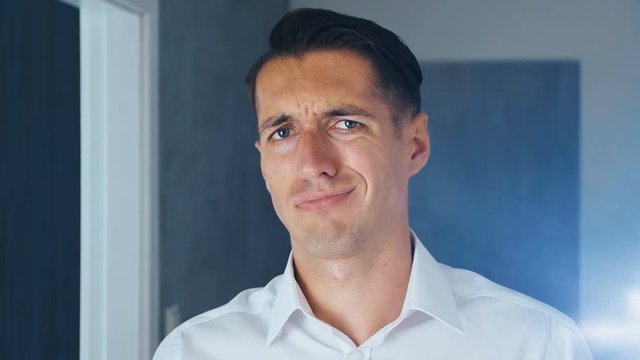 Portrait of shocked and disgusted man. Confused man saw an unpleasant message on a smartphone. He is worried about seeing. Close-up.