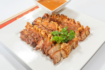 Crispy fried pork belly service with tomato sauce and basil