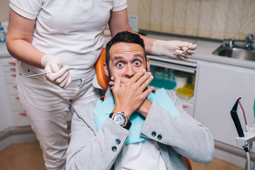 male frightened by dentists covers her mouth