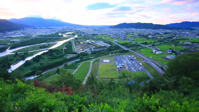 Tilt up of Chikuma River in mountain landscape at sunrise, Japan