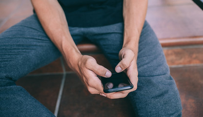 Young man using his smartphone. chatting in social networks with friends. Shopping online.