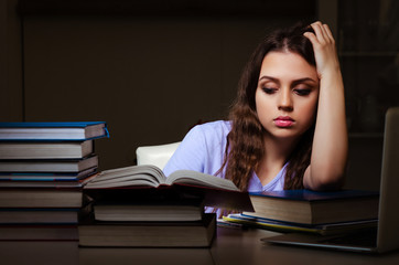 Young female student preparing for exams late at home
