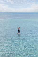 Stand up paddler on the open sea on the blue turquoise water