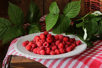 red raspberries on the plate. ripe berries.