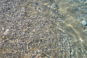 Clear sea water texture, top view of the rocky bottom. Transparent tropical ocean, coral reefs, abstract emerald water surface background