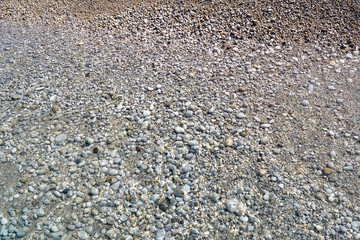 Sea wave moves to a pebble beach. Summer sunny day. View from above