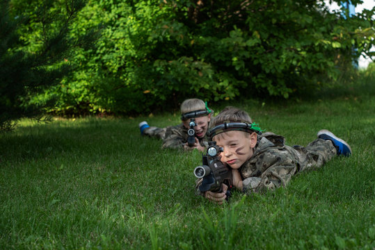 Boys playing in lasertag shooting game, boy with a gun, war simulation.